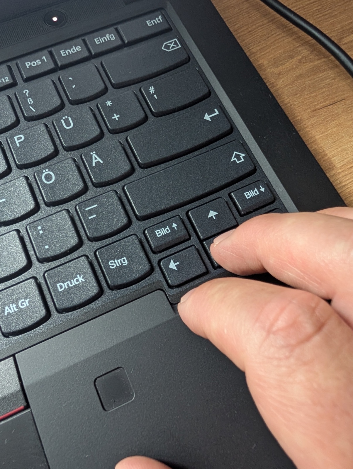 Eine Hand navigiert per Tastatur an einem Laptop